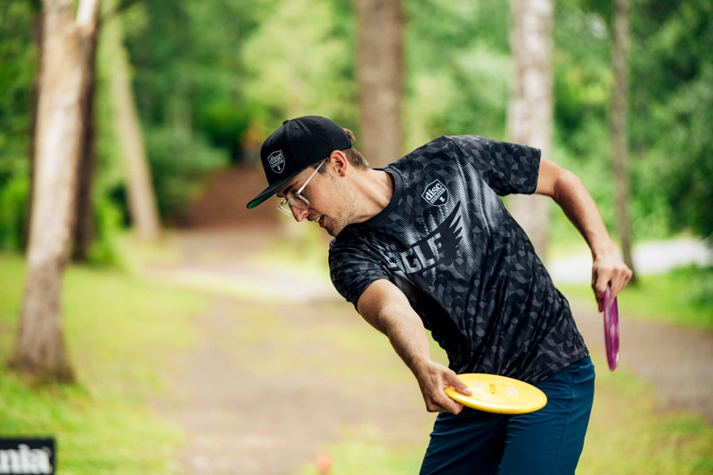 Discgolf player throwing disc